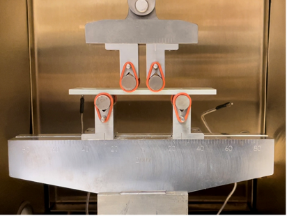 Figure 2. Four-point bending test of Garolite composite rectangular bar in the oven of 3330 Load Frame.